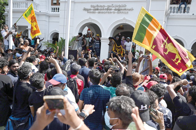 Demonstrators shout slogans and wave Sri Lankan flags during an anti-government protest inside the office building of Sri Lanka's prime minister in Colombo on Wednesday (AFP photo)