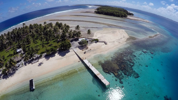 This November 8, 2015, aerial photo shows a small section of the atoll that has slipped beneath the water line only showing a small pile of rocks at low tide on Majuro Atoll in the Marshall Islands (AP photo by Rob Griffith)