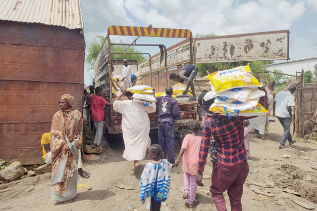 Men load Ethiopian products onto a truck in Sudan's border town of Gallabat on Wednesday (AFP photo)