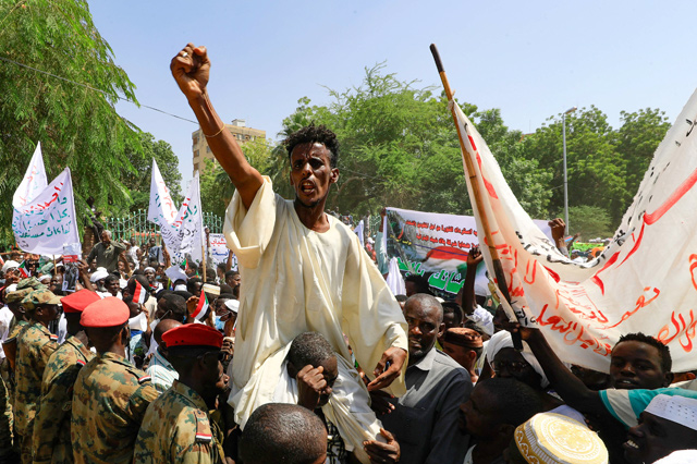 Sudanese protesters take part in a rally demanding the dissolution of the transitional government, outside the presidential palace in Khartoum, on Saturday (AFP photo)