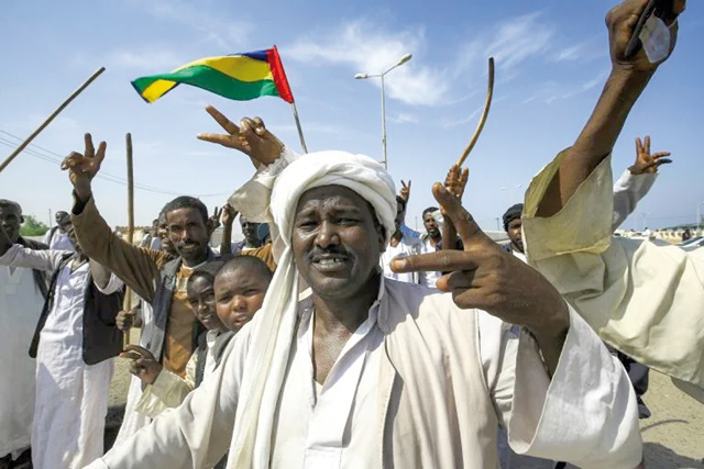 Beja people raise the flag of the Beja Congress political group as they demonstrate outside the Osman Digna port (AFP photo)