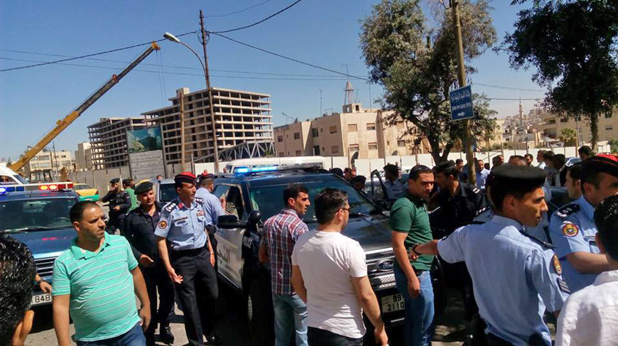 People and police officers are seen near the Interior Ministry Circle, central Amman, where five young men tried to commit suicide by jumping from an abandoned building in the area (Photo courtesy of Maher Shraideh)