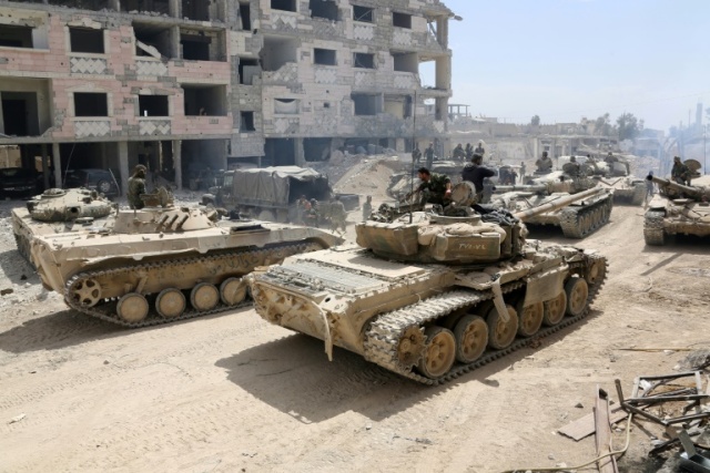 A picture taken on April 8, 2018, shows Syrian Army soldiers gathering in an area on the eastern outskirts of Douma, as they continue their offensive to retake the last opposition holdout in Eastern Ghouta (AFP photo)