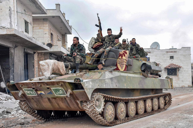 This handout photo released by the official Syrian Arab News Agency on Tuesday shows Syrian army soldiers passing through the captured villages of Deir Sharqi and Talmans on the eastern outskirts of Maaret Al Numan in Syria's northernwestern province of Idlib (AFP photo)