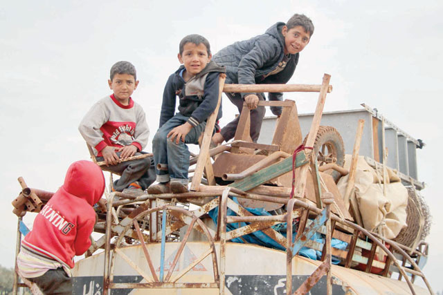 In this photo taken on Saturday, children ride atop a water truck that is also loaded with furniture in the countryside of the village of Saharah, lying on the western edge of Syria's northern Aleppo province by Idlib province (AFP photo)