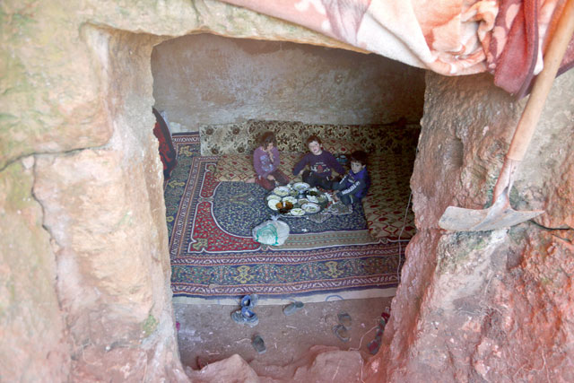 Members of a family of internally displaced Syrians eat together in an underground shelter where several families from Aleppo and Idlib provinces are taking refuge, in the village of Taltunah about 15 kilometres northwest of Idlib in the northwestern Idlib province, on February 23 (AFP photo)