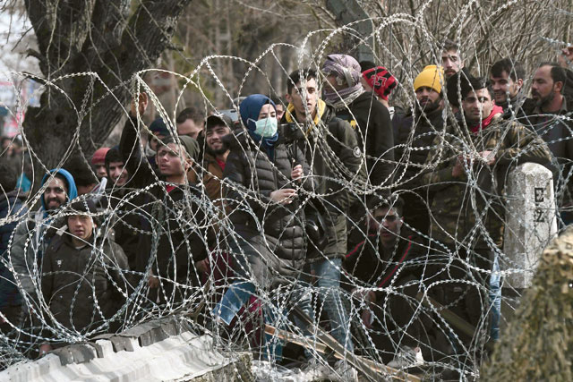This photo taken from the Greek side of the Greece-Turkey border near Kastanies shows migrants waiting on the Turkish side on Sunday (AFP photo)