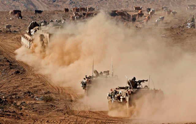 Israeli armoured vehicles take part in a drill in the Israeli-annexed Golan Heights, near the border with Syria, on Tuesday (AFP photo)