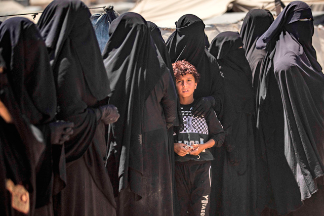 In this file photo taken on August 18, a boy looks on as he stands in line with women to receive aid at the Kurdish-run Al Hol camp in the Al Hasakeh governorate in northeastern Syria (AFP photo)