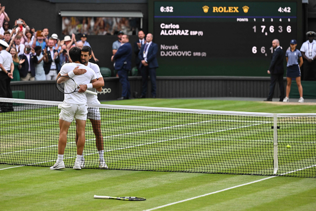 Spain’s Carlos Alcaraz (left) hugs Serbia’s Novak Djokovic after winning their men’s singles final match at the 2023 Wimbledon Championships in London on Sunday (AFP photo by Glyn Kirk)  