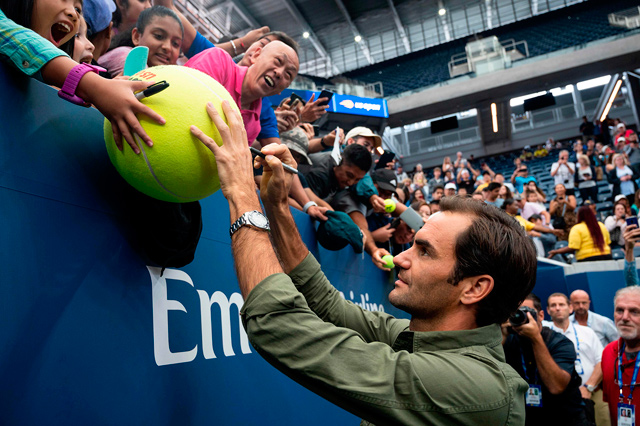 Roger Federer of Switzerland signs autographs after a press conference prior to the US Open on Friday in New York City (AFP photo by Johannes Eisele)