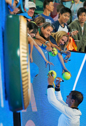 Spain’s Rafael Nadal signs autographs after winning his Men’s singles fourth round match against France’s Gael Monfils  (Reuters photo by Issei Kato)