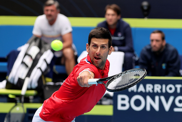 Serbia’s Novak Djokovic hits a return against Canada’s Denis Shapovalov during their group A men’s singles match at the 2021 ATP Cup in Melbourne on Tuesday (AFP photo by David Gray)