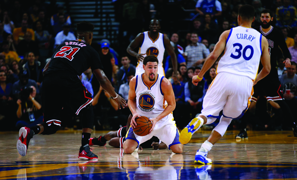 Klay Thompson of the Golden State Warriors passes the ball to Stephen Curry while Jimmy Butler of the Chicago Bulls plays defence on Friday in Oakland (AFP photo by Ezra Shaw)