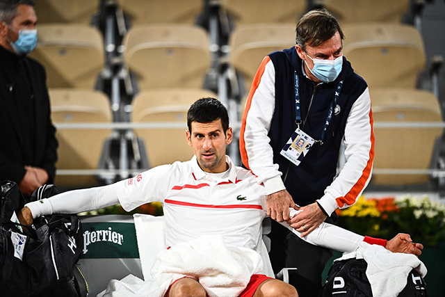 Serbia's Novak Djokovic reacts as he is treated by medical staff during his men's singles quarter-final match against Spain's Pablo Carreno Busta on Day 11 of The Roland Garros 2020 French Open tournament in Paris on Wednesday (AFP photo by Anne-Christine Poujoulat)