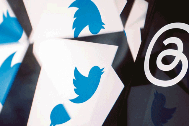 Photo illustration shows the Twitter logo reflected near the logo for Threads (AFP photo by Stefani Reynolds)