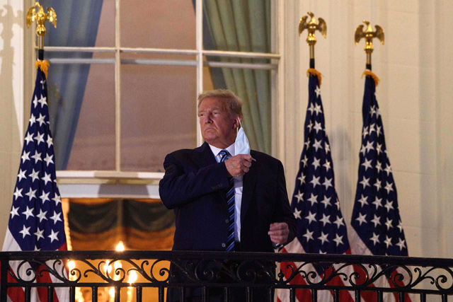 US President Donald Trump takes off his face mask as he arrives at the White House upon his return from Walter Reed Medical Centre, where he underwent treatment for COVID-19, in Washington, DC, on Monday (AFP photo)
