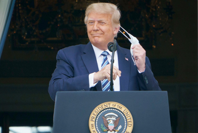 US President Donald Trump takes his mask off before speaking from the South Portico of the White House in Washington, DC, during a rally on Saturday (AFP photo)