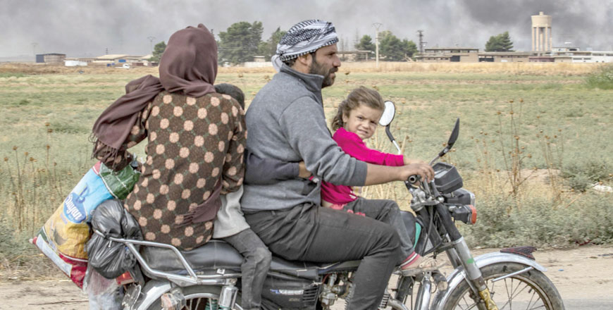 Members of a Syrian family use a motorcycle to flee the countryside of the north-eastern Syrian town of Ras Al Ain on the Turkish border, towards the west to the town of Tall Tamr, on Saturday (AFP photo)