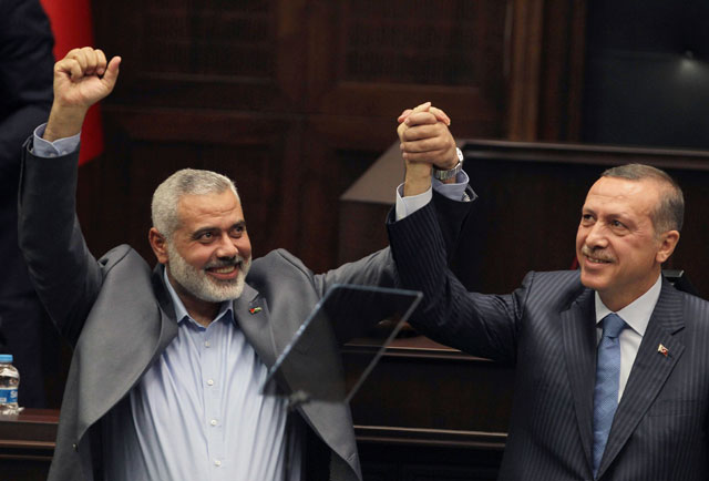 In this January 3, 2012 file photo, Gaza's Hamas Prime Minister Ismail Haniyeh (left) and then Turkish Prime Minister Recep Tayyip Erdogan salute together the lawmakers and supporters of Erdogan's Islamic-rooted Justice and Development Party at the parliament in Ankara, Turkey (AP photo)
