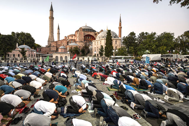 People, some wearing face masks, pray outside the Hagia Sophia museum in Istanbul on Friday as they gather to celebrate after a top Turkish court revoked the sixth-century Hagia Sophia's status as a museum, clearing the way for it to be turned back into a mosque (AFP photo)