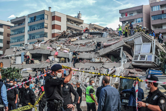 Rescuers search for survivors at a collapsed building after a powerful earthquake struck Turkey's western coast and parts of Greece, in Izmir, on Friday (AFP photo)