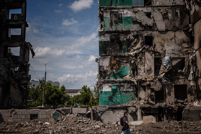 A woman walks past a destroyed building in the town of Borodyanka on Wednesday, amid the Russian invasion of Ukraine (AFP photo)