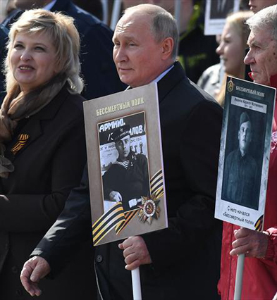 Russian President Vladimir Putin and other participants carry portraits of their relatives — WWII soldiers — as they take part in the Immortal Regiment march on Red Square in central Moscow on Monday. Russia celebrates the 77th anniversary of the victory over Nazi Germany during World War II (AFP photo)