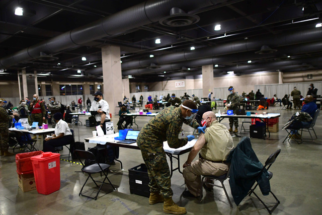 A member of the US Armed Forces administers a COVID-19 vaccine at a FEMA community vaccination centre on Tuesday in Philadelphia, Pennsylvania. Located at the Pennsylvania Convention Centre, the site is being run as a partnership between the city and the federal government (AFP photo)