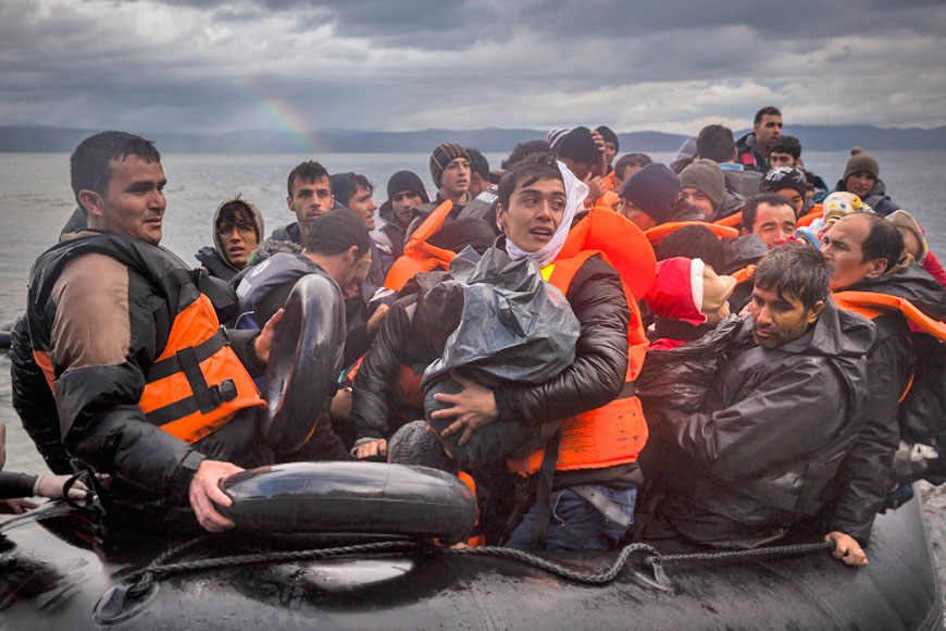 Refugees and migrants arrive on a beach following a crossing of a part of the Aegean Sea from the Turkey's coast to the Greek island of Lesbos, on Saturday (AP photo)