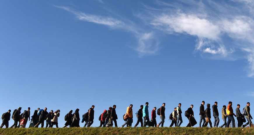 Migrants walk to a first registration point of the German federal police after they crossed the Austrian-German border in the small Bavarian village of Simbach, southern Germany, on Monday (AFP photo)