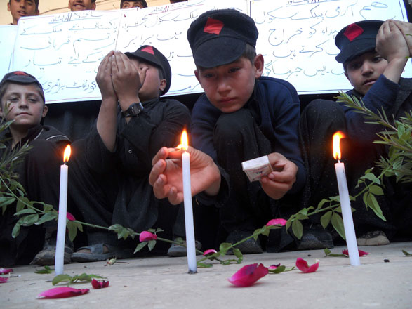 A Pakistani student lights a candle to mark the first anniversary of the Peshawar school massacre which left more than 150 people dead at a government school in Kohat on Wednesday (AFP photo)