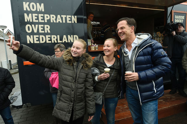 Dutch Prime Minister Mark Rutte (right) poses for a ‘selfie’ with local citizens in Wormerveer on Saturday as he campaigns for  reelection ahead of the March 15 vote (AFP photo)