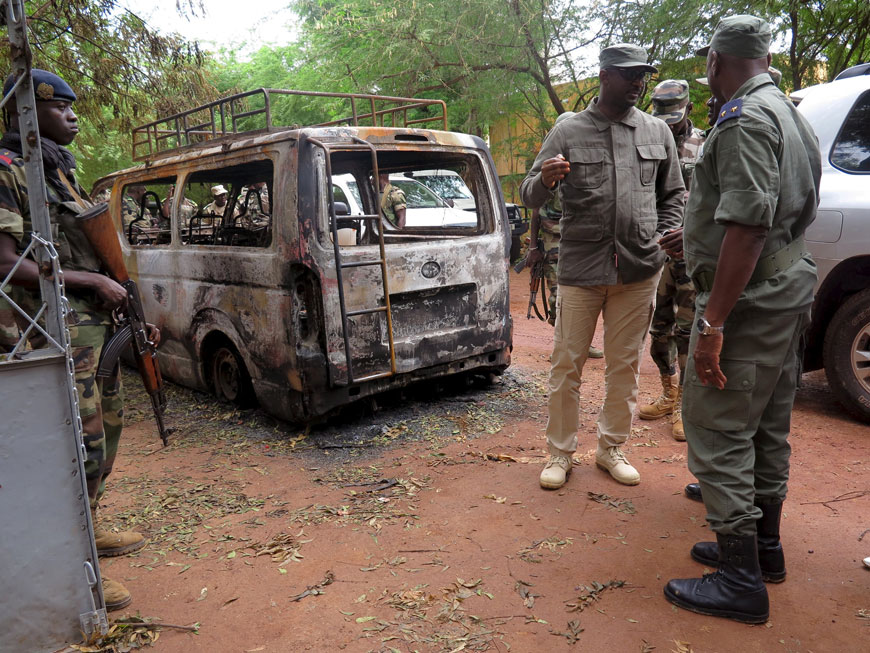 Malian Defence Minister Tieman Coulibaly (centre) surveys the damage after a hotel siege over the weekend in which 17 people died in Sevare, Mali in this August 11 file photo (Reuters photo)