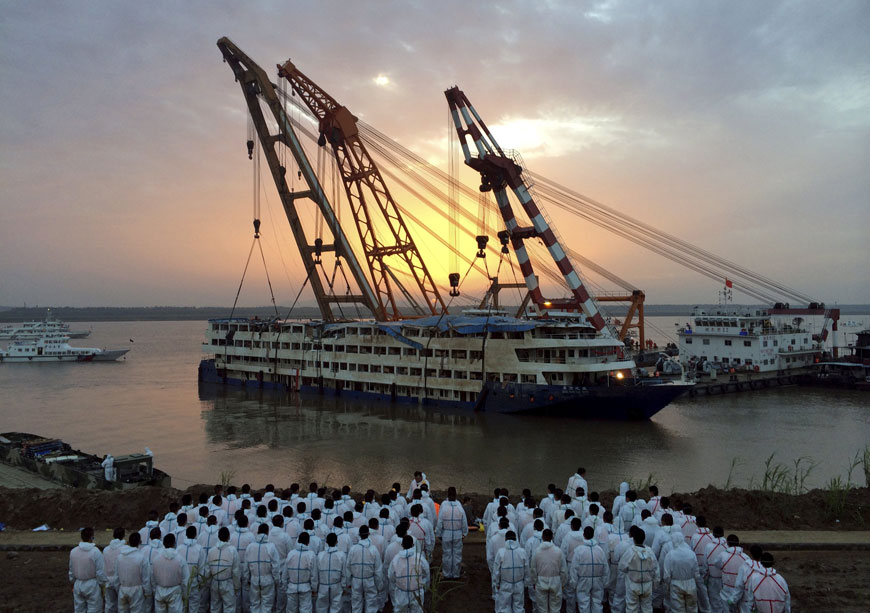 Rescue workers stand on the river bank as the capsized cruise ship Eastern Star is pulled out of the Yangtze against sunset, in Jianli, Hubei province, China, on Friday (Reuters photo)