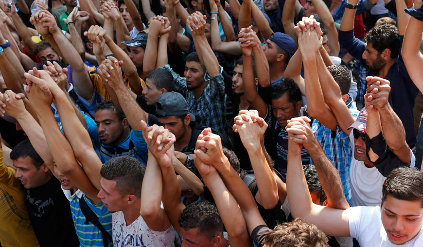 Syrian refugees raise their arms in front of the railway station in Budapest, Hungary, Wednesday (Reuters photo)