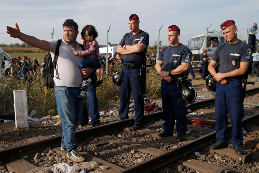 A migrant with his child talks to the police officers after Hungarian police sealed the border with Serbia near the village of Horgos, Serbia, on Monday, near the Hungarian migrant collection point in Roszke (Reuters photo)