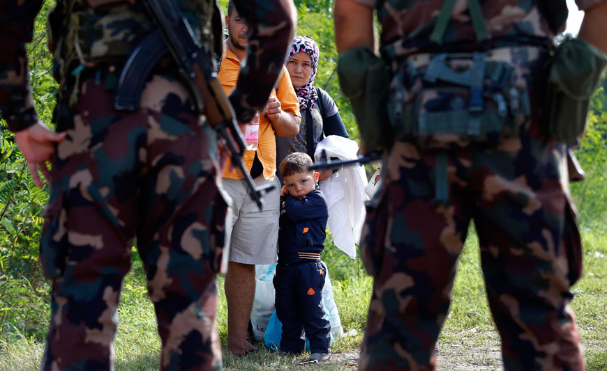 Hungarian soldiers stop a migrant family at the border exit between Serbia and Hungary in Asotthalom near Roszke, southern Hungary, on Tuesday (AP photo)