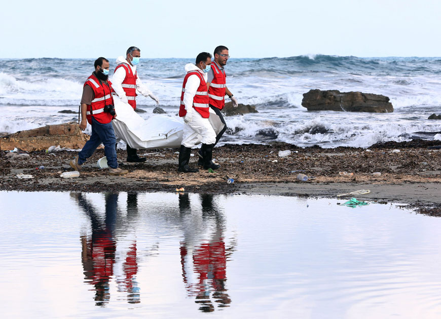 Libyan Red Crescent personnel work on recovering the bodies of 14 people thought to be migrants that were discovered on a beach near Khoms, some 120km east of Tripoli, on Sunday (AFP photo)