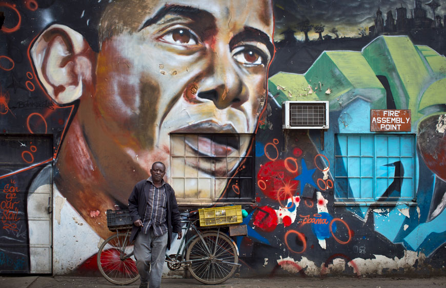 A man walks away after leaning his bicycle against a mural of President Barack Obama, created by the Kenyan graffiti artist Bankslave, at the GoDown Arts Centre in Nairobi, Kenya, Wednesday (AP photo)