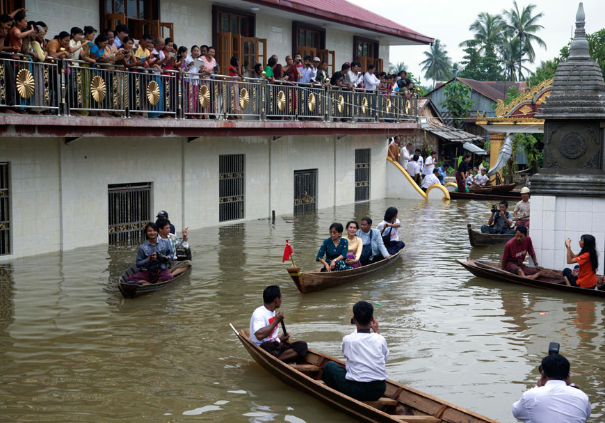 Myanmar opposition leader Aung San Suu Kyi (centre) rides a boat as she leaves after visiting a monastery where flood victims are sheltered in Bago, 80 kilometres northeast of Yangon, Myanmar, on Monday (AP photo)