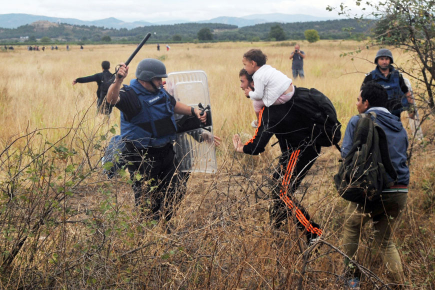 A migrant tries to pass a fence near the town of Idomeni, on the border between former Yugoslav Republic of Macedonia and Greece, on Saturday (AFP photo)