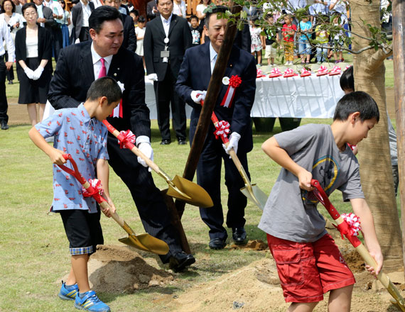 Noraha Mayor Yukiei Matsumoto (rear left) plants a tree with children of Naraha residents during an event in Naraha, northern Japan, on Saturday (AP photo)