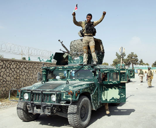 An Afghan soldier raises his hands as a victory sign in Kunduz city, north of Kabul, on Friday (AP photo)