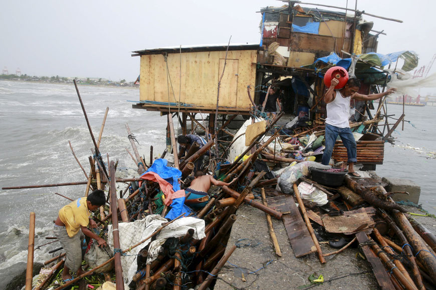 A family living along the coast of Manila Bay searches for salvageable items after their house was damaged  by strong winds brought by Typhoon Koppu on Sunday (Reuters photo)
