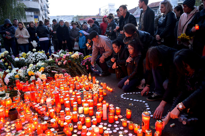People light candles to commemorate the victims outside the nightclub Colectiv in Bucharest on Saturday (AFP photo)