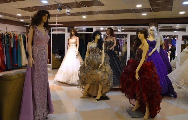Evening wear and wedding dresses are displayed in a showroom in Mosul. Iraq’s second city is a bastion of traditionalism and conservatism, but suitors are finding it increasingly hard to save enough cash to fund a dowry and a wedding  (AFP photo)