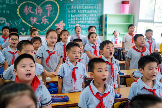 Elementary school students attend a class on the first day of the new semester in Wuhan in China's central Hubei province on Tuesday (AFP photo)