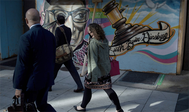 People walk past a painting of the late Ruth Bader Ginsburg, who served as an associate justice of the US Supreme Court, as the court hears the latest challenge to the Affordable Care Act on Tuesday, in Washington, DC (AFP photo)