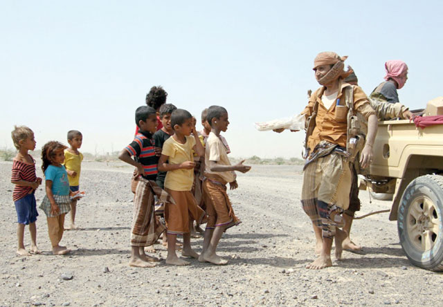 Pro-government fighters give food to Yemeni children on January 26, 2017 (AFP photo)